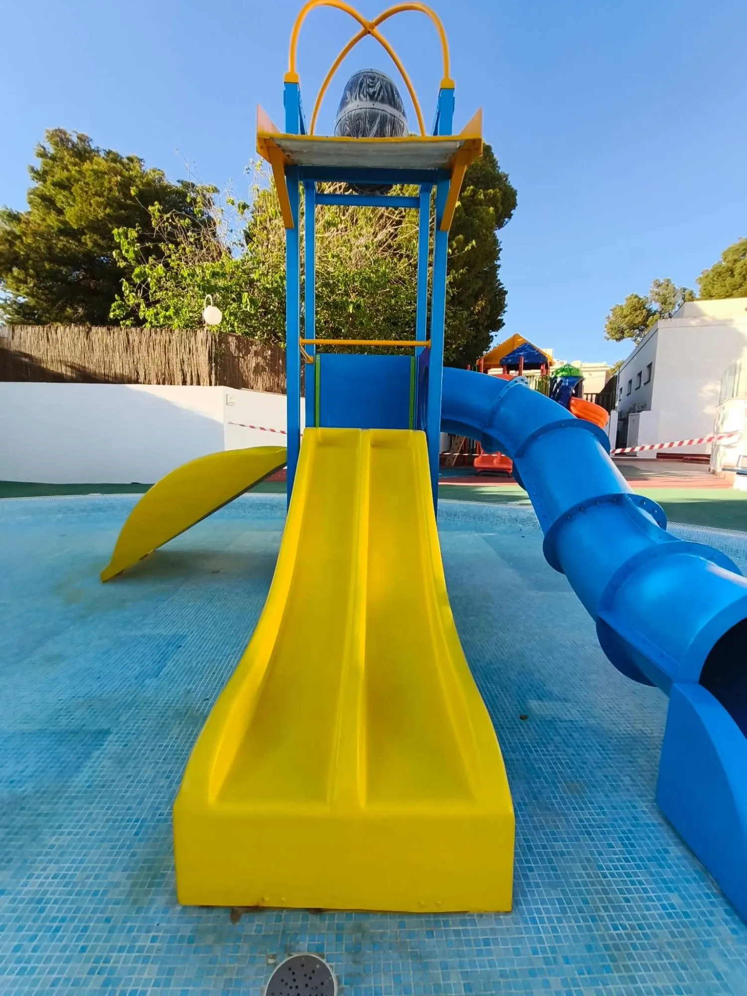 La misma torre de juegos acuáticos restaurada, con los toboganes amarillo y azul como nuevos