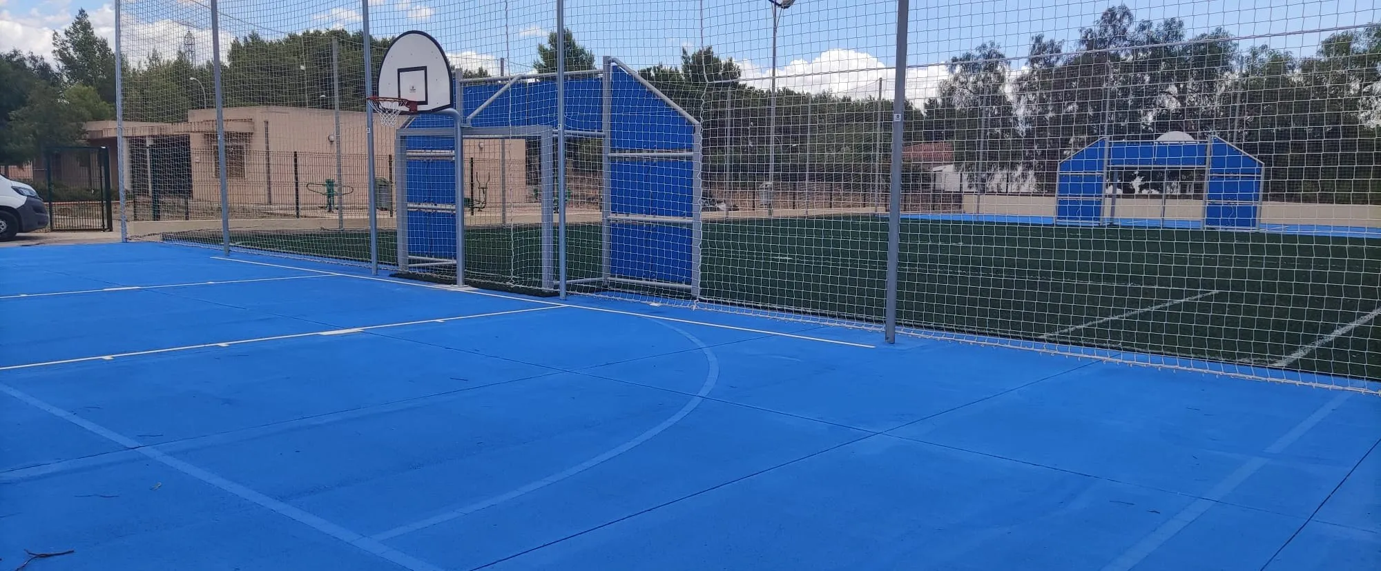 Pista multideporte azul terminada con porterías y césped artificial
