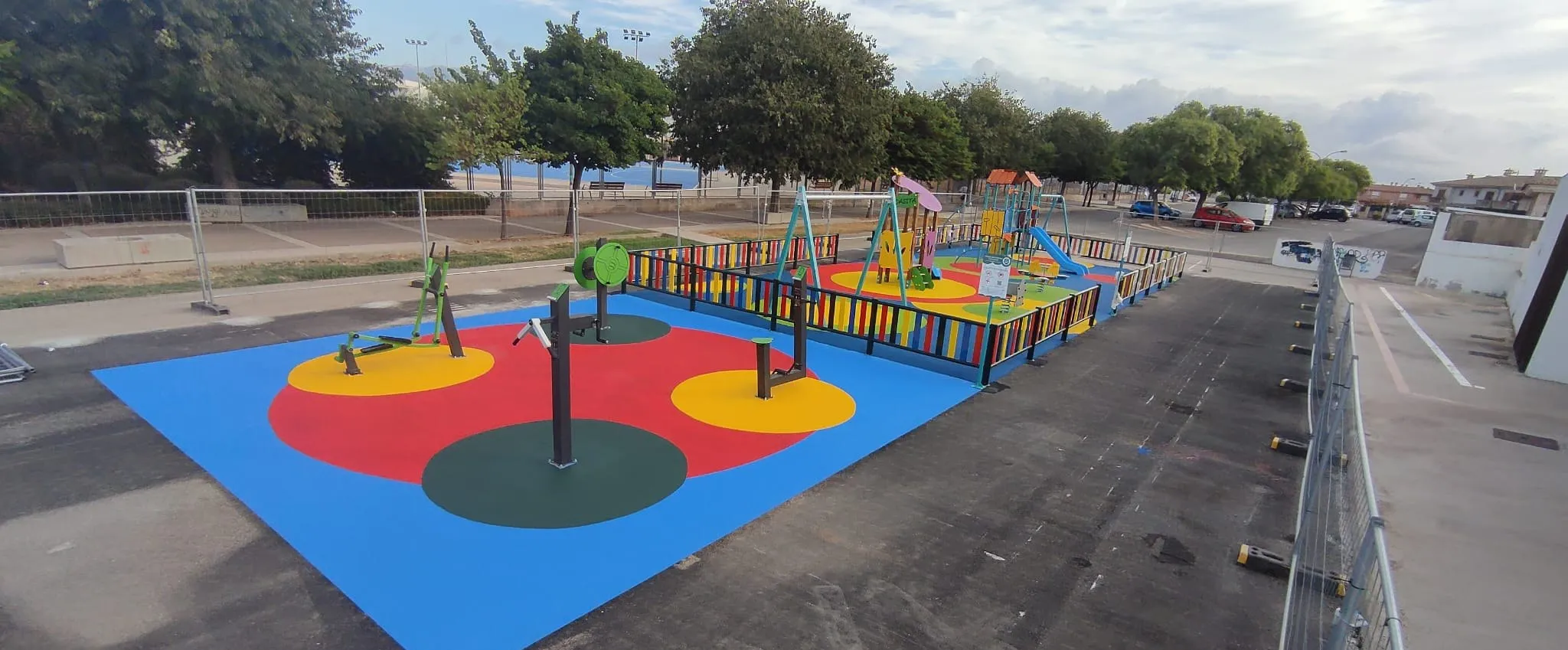 Área de juego con columpio y aparatos dinámicos en una plaza