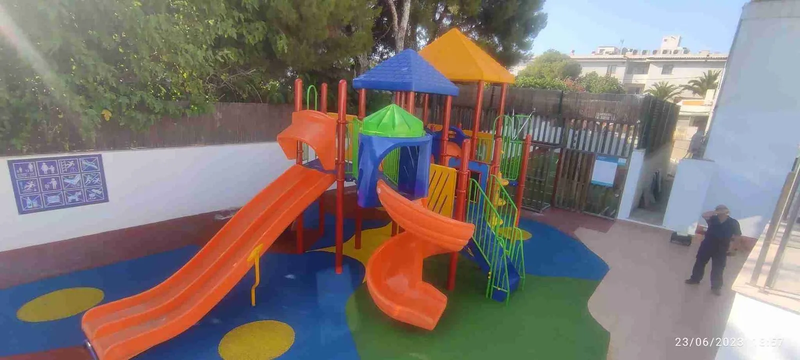 Parque infantil con toboganes y valla perimetral de colores