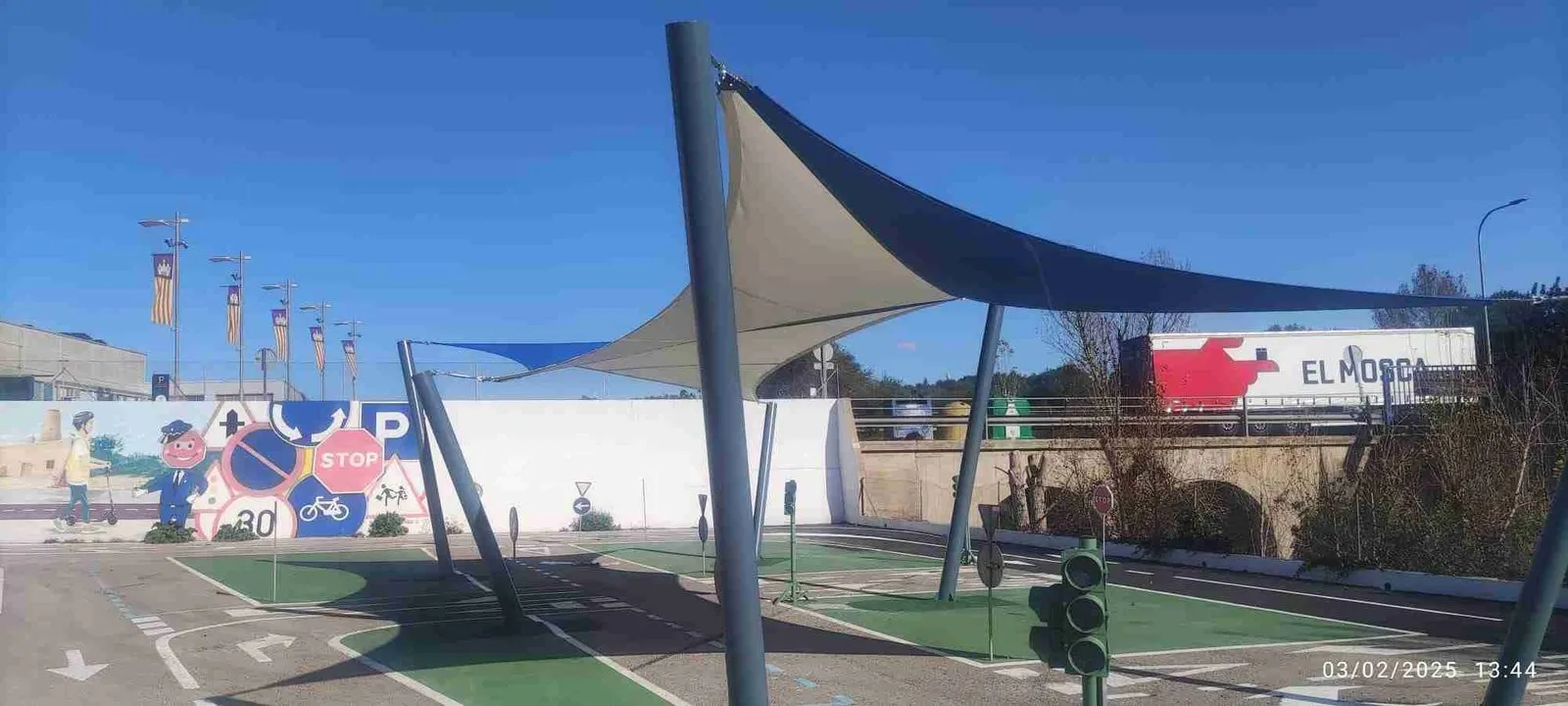 Vela de sombra azul y blanca instalada sobre una pista